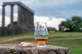 Glass of single malt scotch whisky and view from Calton hill to park and old parts of Edinburgh city in rainy day, Scotland, UK Royalty Free Stock Photo