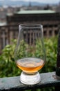 Glass of single malt scotch whisky and view from Calton hill to park and old parts of Edinburgh city in rainy day, Scotland, UK Royalty Free Stock Photo