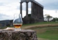 Glass of single malt scotch whisky and view from Calton hill to park and old parts of Edinburgh city in rainy day, Scotland, UK Royalty Free Stock Photo