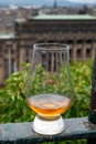 Glass of single malt scotch whisky and view from Calton hill to park and old parts of Edinburgh city in rainy day, Scotland, UK Royalty Free Stock Photo