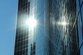 A glass skyscraper with the sun glistening