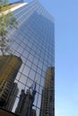 Glass skyscraper tall modern building, reflection, blue sky, vertical
