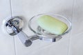 Glass soap dish with chrome base, attached to the bathroom wall