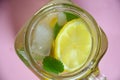 Glass of soda drink with lemon slices and mint on pink background. From top view. glass of lemon ice tea or detox water Royalty Free Stock Photo