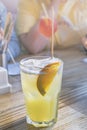 Glass of soda with orange slice and eco friendly tube on wooden table in cafe. People drinking squash using eco bamboo straw.