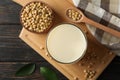 Glass of soy milk and soybeans seeds on wooden background, space for text Royalty Free Stock Photo