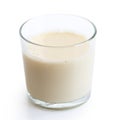 Glass of soya milk with froth on white.