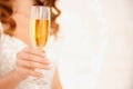 Glass of sparkles champagne in hands of girl with manicure, blurred background. Concept Christmas holidays and party Royalty Free Stock Photo