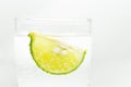 Glass sparkling water with ice cubes and slice of lime isolated. Royalty Free Stock Photo