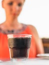 A glass of sparkling water on the table and a woman in the background. Royalty Free Stock Photo