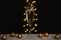 A glass of sparkling wine with golden christmas ornaments with love shape bokeh lights Royalty Free Stock Photo