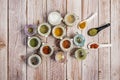 Glass spice jars with peppercorns, paprika powder, yellow curry, porcelain spoons with oregano, salt flakes,