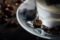 A glass of spicy latte with whipped cream and cinnamon, standing on a brown board. Coffee beans. Dark background Royalty Free Stock Photo