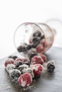 Glass of spilled berries and sugar on a slate plate