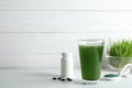 Glass of spirulina drink, pills and powder on table. Royalty Free Stock Photo