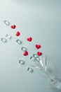 Glass with splash of red heart shaped sugar candy and ice. Over blue background. Valentines Day Royalty Free Stock Photo