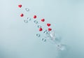 Glass with splash of red heart shaped sugar candy and ice. Over blue background. Valentines Day, Royalty Free Stock Photo