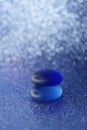 Glass stones on a shiny blue table with a blurred background in ice bubbles Royalty Free Stock Photo