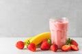 Glass of strawberry and banana smoothie or milkshake with fresh fruits and berries. refreshing summer drink Royalty Free Stock Photo