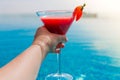 A glass of strawberry cocktail in female hands. Swimming pool Royalty Free Stock Photo