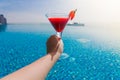 A glass of strawberry cocktail in female hands. Swimming pool Royalty Free Stock Photo