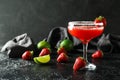 Glass of strawberry daiquiri cocktail, limes and berries on dark background Royalty Free Stock Photo