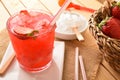 Glass of strawberry juice with ice on wooden table detail Royalty Free Stock Photo