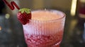 A glass of strawberry juice at the table with a fancy straw