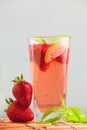 Glass of strawberry lemonade with pieces of strawberry, lemon and fresh mint. Royalty Free Stock Photo