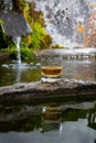Glass of strong scotch single malt whisky served on old stone reservoir for water from mountain spring