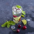 Glass of Summer lemonade or ice tea. Refreshing cool detox drink with cherry and mint on dark background.Mojito cocktail with ice Royalty Free Stock Photo