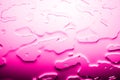 Glass surface with spilled water, bright pink color, shiny drops texture, wet background, light purple gradient, close up Royalty Free Stock Photo