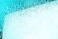 Glass surface with water drops, bright blue color, shiny drops texture, wet background, light white and blue gradient close up