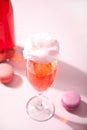 Glass with sweet cotton candy pink cocktail and bottle on background Royalty Free Stock Photo