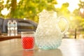 glass of sweet drink with jar on wooden table background. Royalty Free Stock Photo