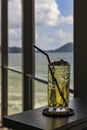 A glass of sweet and refreshing water is placed on a table on a wooden balcony in a restaurant by the sea. the background is the Royalty Free Stock Photo