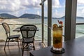 A glass of sweet and refreshing water is placed on a table on a wooden balcony in a restaurant by the sea. the background is the Royalty Free Stock Photo