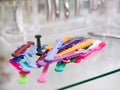 Glass table with multicolored orthodontic ligatures for braces. Royalty Free Stock Photo