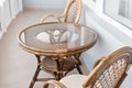 Glass table and rattan wicker seat chair. Wicker furniture rattan table two chairs near the window on balcony Royalty Free Stock Photo