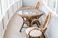 Glass table and rattan wicker seat chair. Wicker furniture rattan table two chairs near the window on balcony Royalty Free Stock Photo