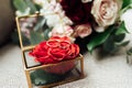 On the glass table in the room is a box with wedding rings, next to it is a bouquet of flowers Royalty Free Stock Photo