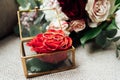 On the glass table in the room is a box with wedding rings, next to it is a bouquet of flowers Royalty Free Stock Photo