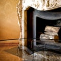 Glass table top with a blurred fireplace and luxury home interior background. Empty space background for your products and decorat Royalty Free Stock Photo