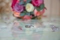 Glass table . Wedding rings next to a red flower bouquet selective focuse . Bride and groom with Engagement gold rings put on the Royalty Free Stock Photo