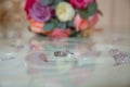 Glass table . Wedding rings next to a red flower bouquet selective focuse . Bride and groom with Engagement gold rings put on the Royalty Free Stock Photo