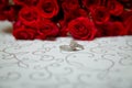 Glass table . Wedding rings next to a red flower bouquet selective focuse . Bride and groom with Engagement gold rings Royalty Free Stock Photo