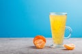 Glass of tangerine orange colored drink with basil seeds on a gray and blue background. Side view Royalty Free Stock Photo