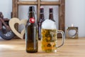 Glass tankard of chilled beer with a bottle