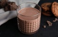 Glass of tasty chocolate milk on dark table. Dairy drink