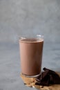 Glass of tasty chocolate milk on gray table. Dairy cacao drink